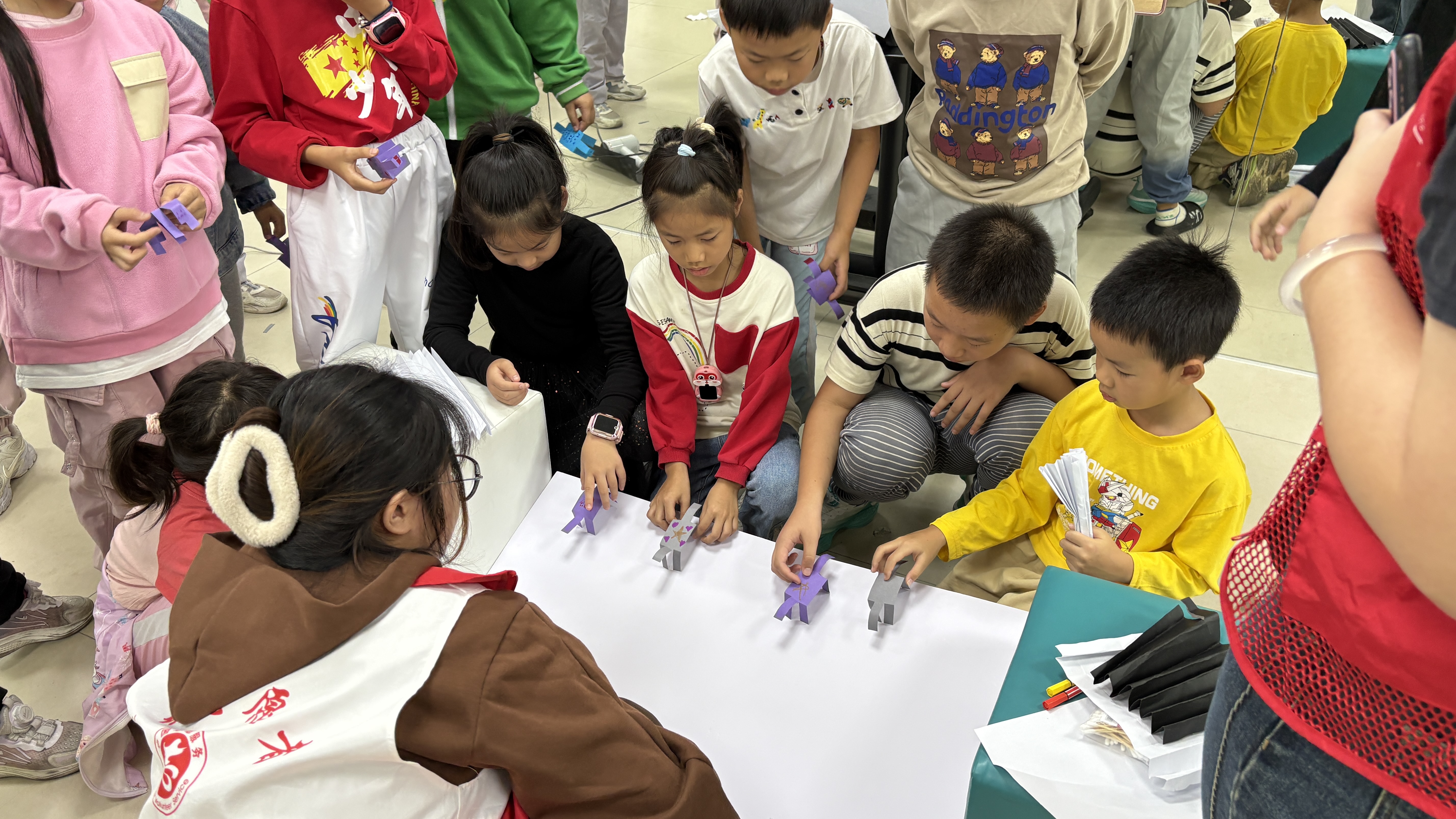 大学生志愿者带社区小朋友进行“会走的纸小马”实验。通讯员供图